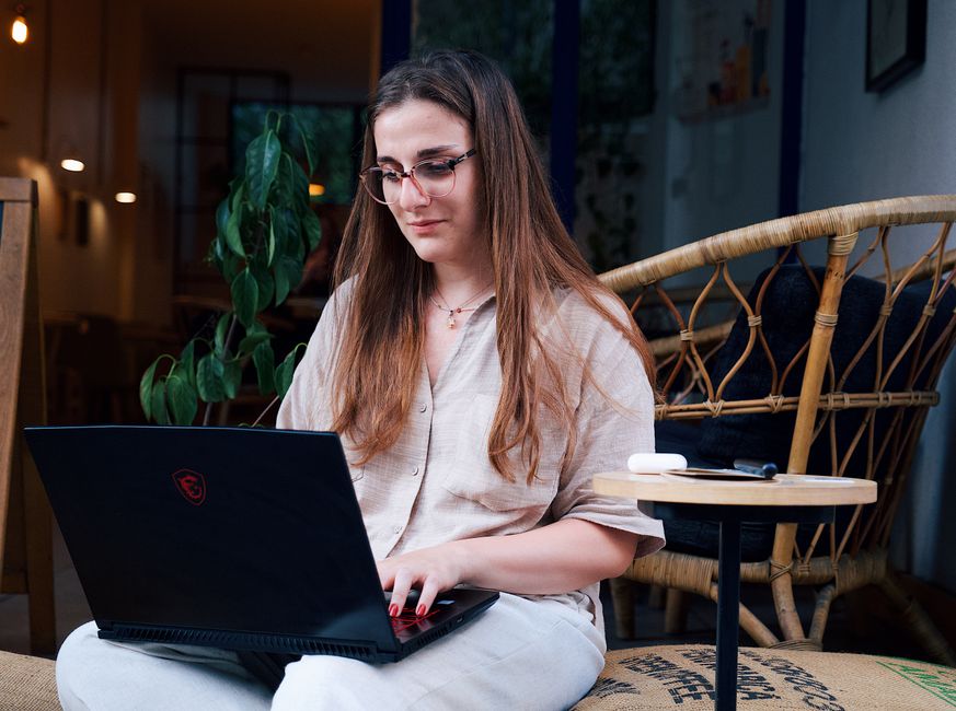 Jeune femme travaillant à distance sur un ordinateur portable
