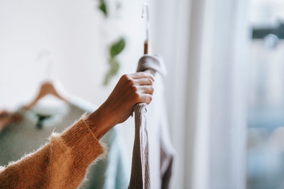 Une femme choisit des vêtements dans son armoire.
